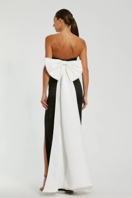 Elegante vestido strapless negro que se ajusta a la silueta, con un escote que realza los hombros. En la parte trasera, un delicado moÃ±o blanco aÃ±ade un toque romÃ¡ntico y distintivo, creando un contraste encantador.